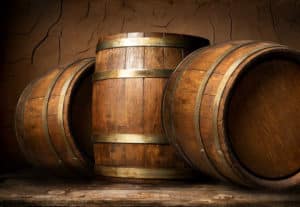 Old wooden barrels in cellar with clay wall