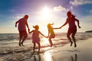 41118428 - happy family jumping together on the beach